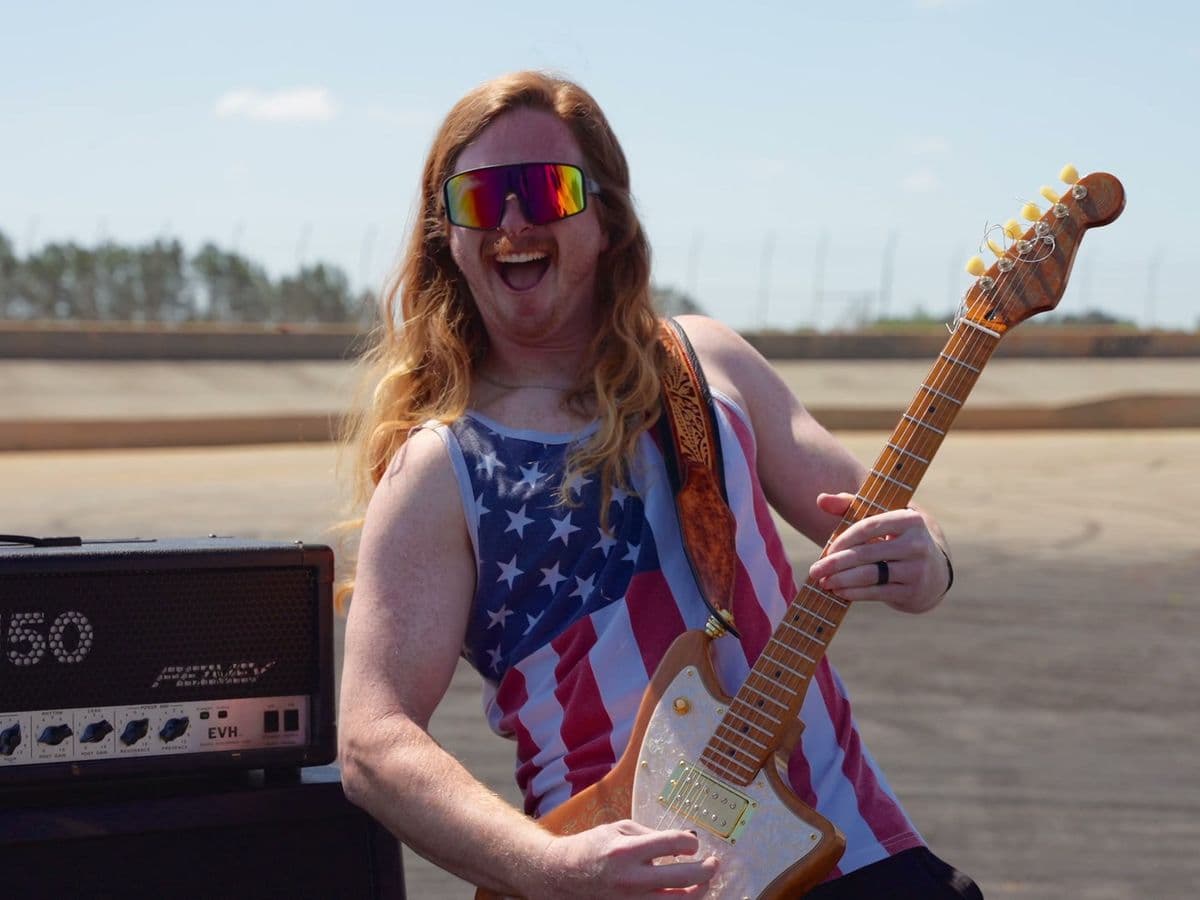 The Florida Man shredding guitar in an American flag tank top