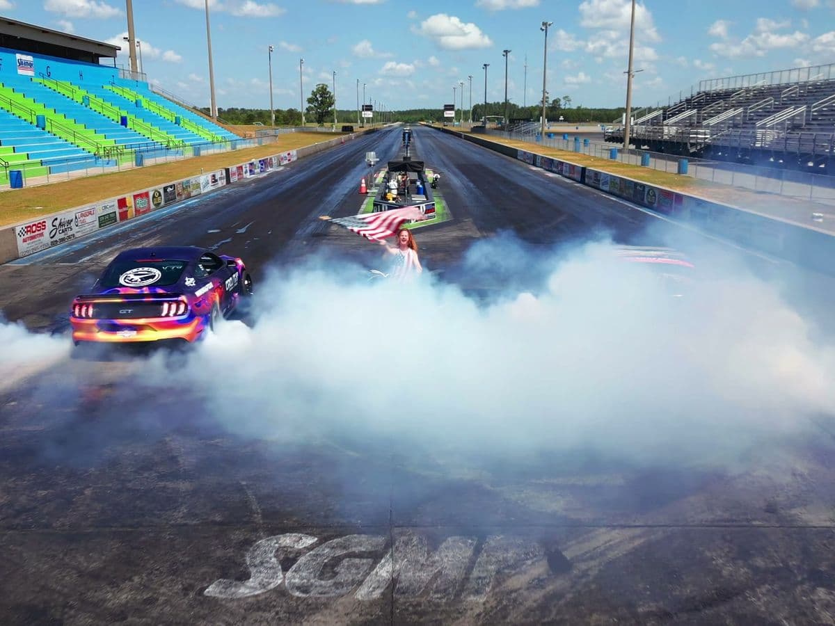 A drag car disappearing into a wall of tire smoke