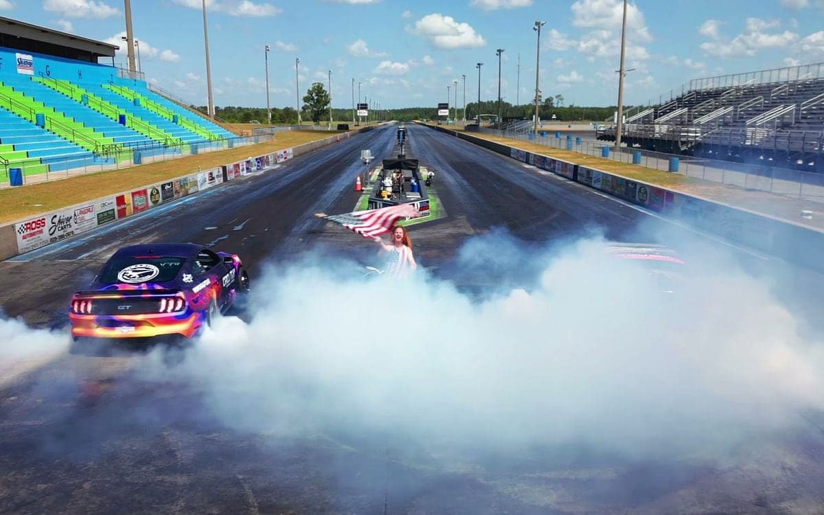 A drag car disappearing into a wall of tire smoke